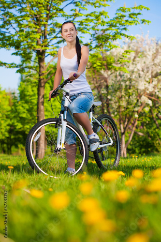 woman in a green park on a bike © Dmytro Titov
