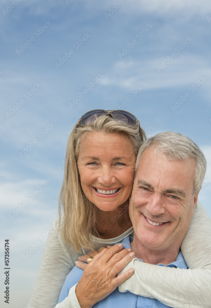 Man Piggybacking Woman Against Cloudy Sky