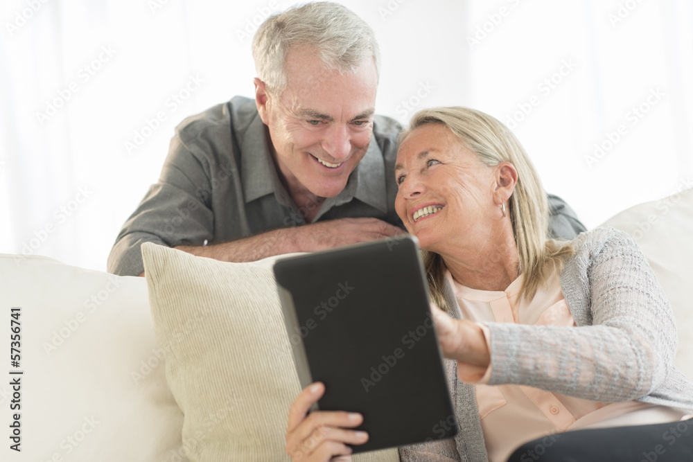 Woman Showing Digital Tablet To Man At Home Woman Showing Digital Tablet To Man At Home