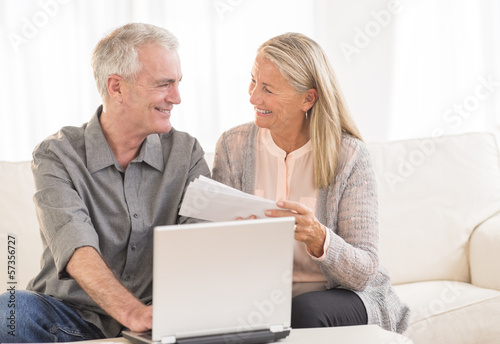 Couple With Laptop Paying Bills Online At Home