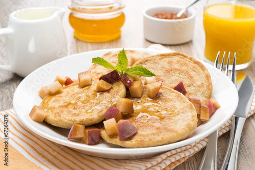 homemade pancakes with peaches and honey on the plate