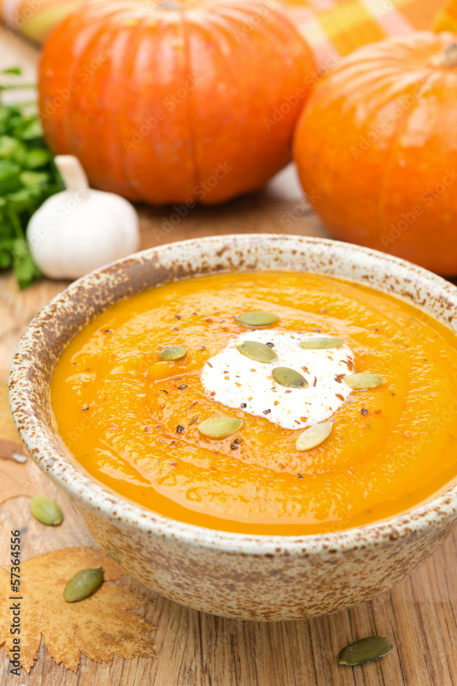 pumpkin soup with coriander and cream in a bowl, vertical pumpkin soup with coriander and cream in a bowl, vertical