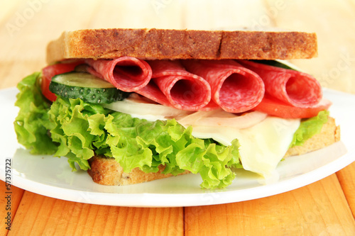 Foto Tasty sandwich with salami sausage and vegetables