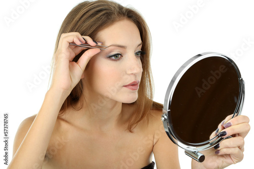 Young woman plucking eyebrows isolated on white photo