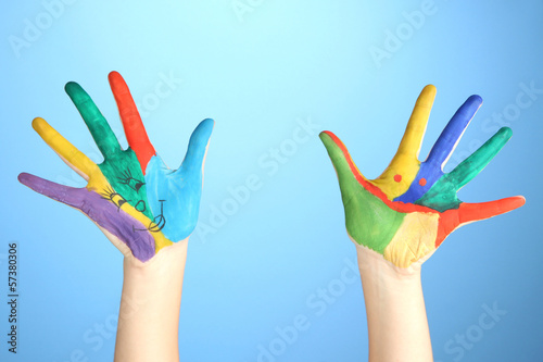 Painted hands with smile on blue background