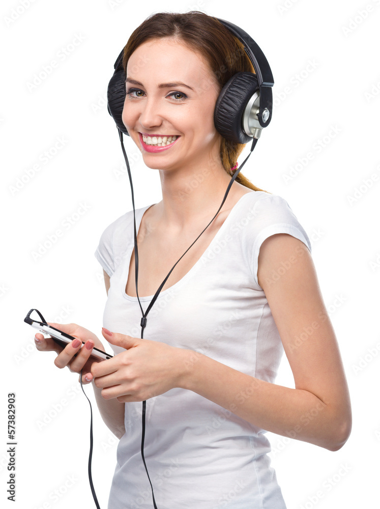 Young woman enjoying music using headphones Young woman enjoying music using headphones