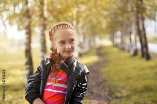 Charming little girl posing in autumn garden