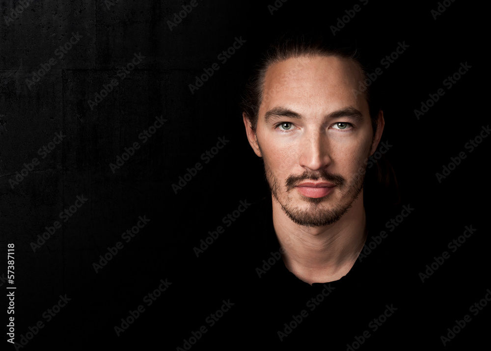 Closeup portrait of young man above black background