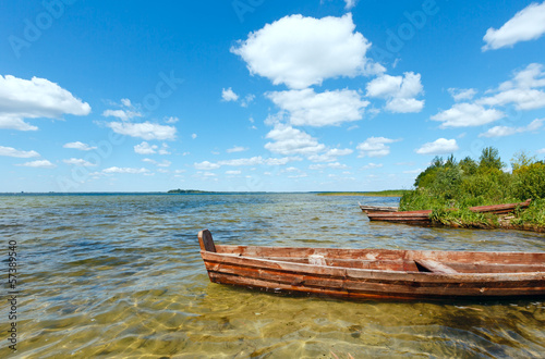 Summer lake view with wooden boats.