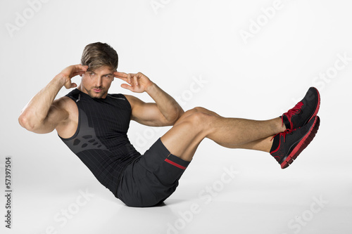 junger Mann beim Krafttraining und Muskelaufbau macht Sit ups