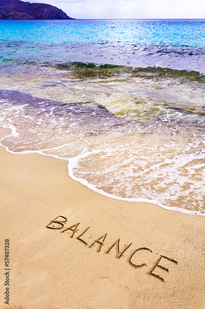 Fototapeta premium Word BALANCE written on sand, with sea waves in background