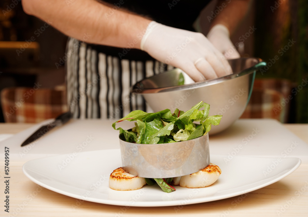 Chef is cooking appetizer with scallops Chef is cooking appetizer with scallops