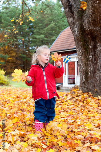 Kleines blondes Mädchen sammelt Herbstlaub photo