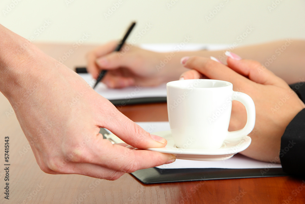 Close up of businesswoman hands with cup of coffee during Close up of businesswoman hands with cup of coffee during