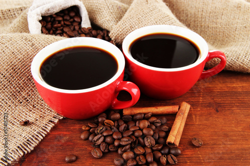 Red cups of strong coffee and coffee beans