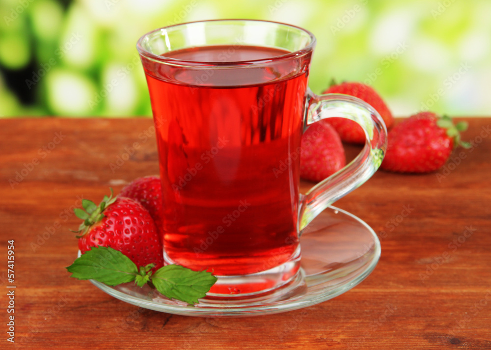 Delicious strawberry tea on table on bright background Delicious strawberry tea on table on bright background