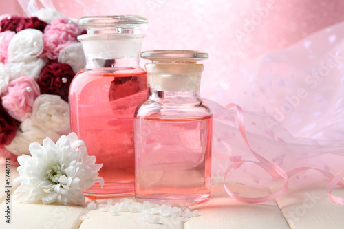 Glass bottles with color essence, on pink background