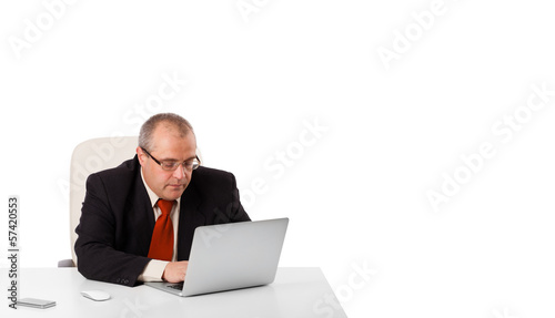 buisnessman sitting at desk and looking laptop with copy space © ra2 studio