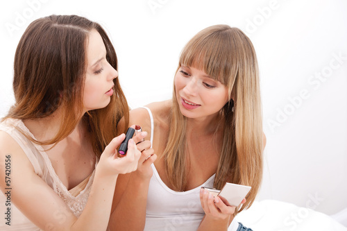 Group of women applying makeup on face