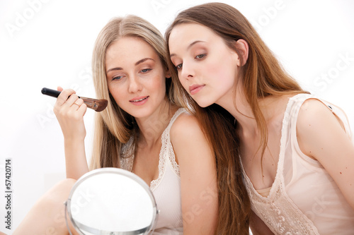 Group of women applying makeup on face