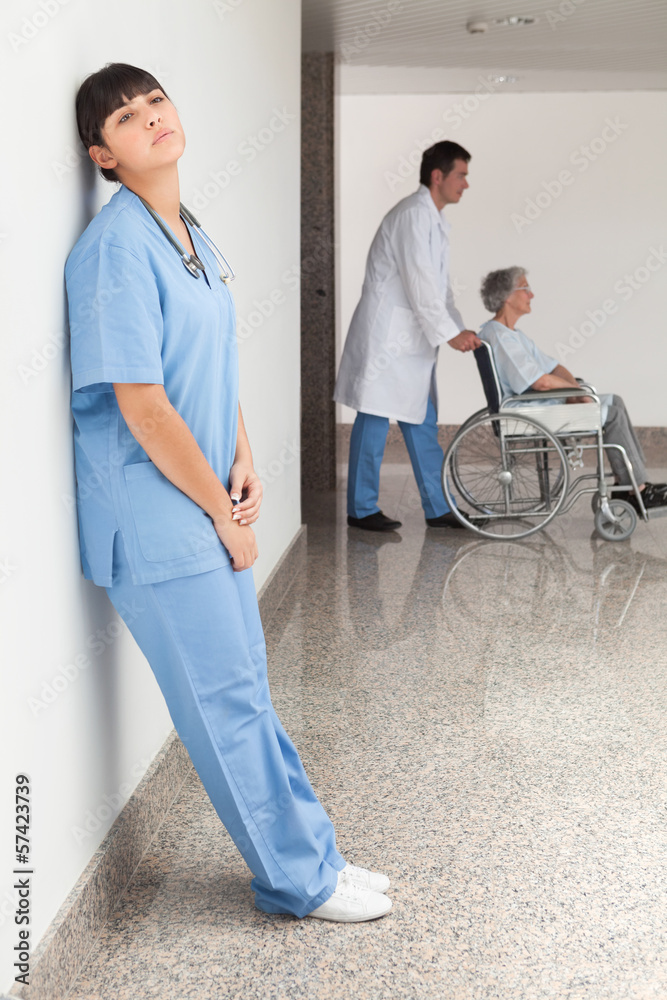 Obraz premium Tired nurse leaning against wall