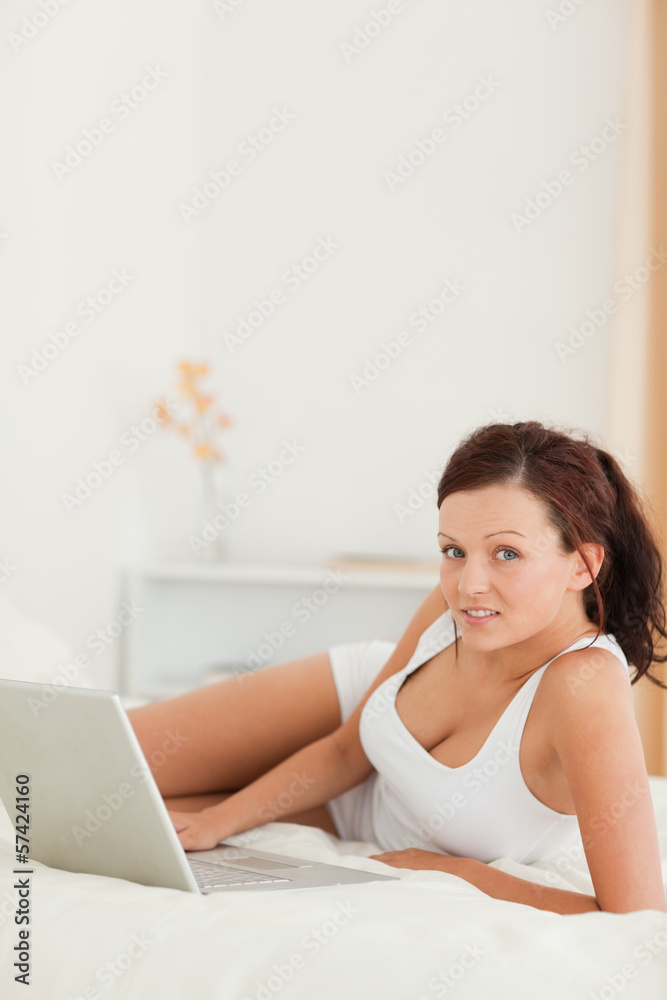 Relaxed woman with a laptop looking into the camera Relaxed woman with a laptop looking into the camera