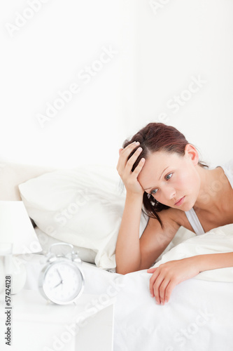 Close up of a tired red-haired woman waking up