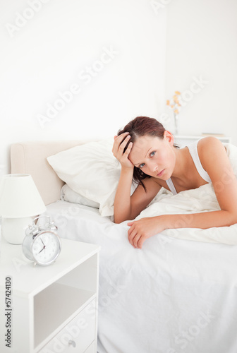 Cute red-haired woman waking up looking into the camera