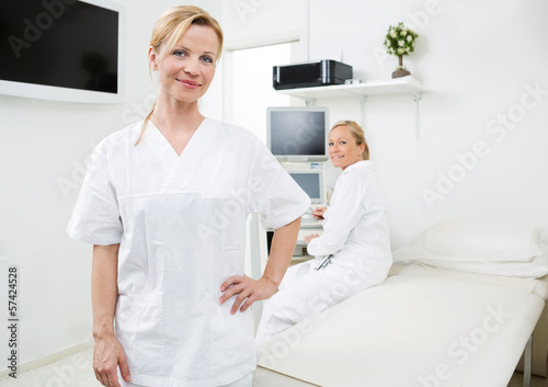 Confident Gynecologist With Colleague In Background