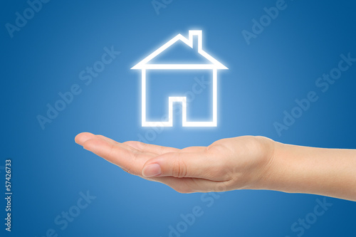 Virtual house with woman hand on blue background .