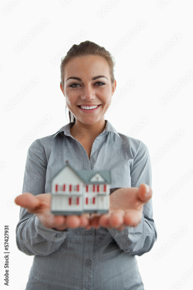 Young female estate agent presenting miniature house Young female estate agent presenting miniature house