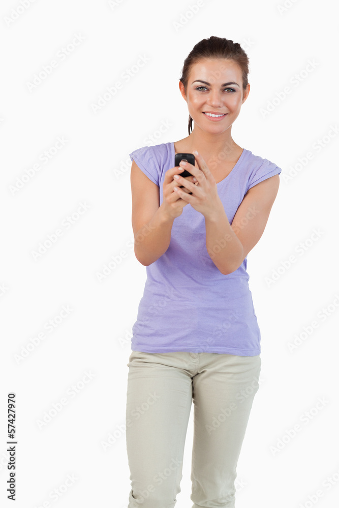 Smiling young female holding her cellphone Smiling young female holding her cellphone