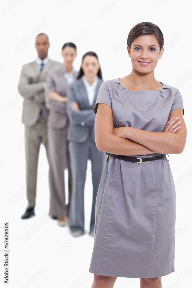 Woman smiling with her business team crossing their arms Woman smiling with her business team crossing their arms
