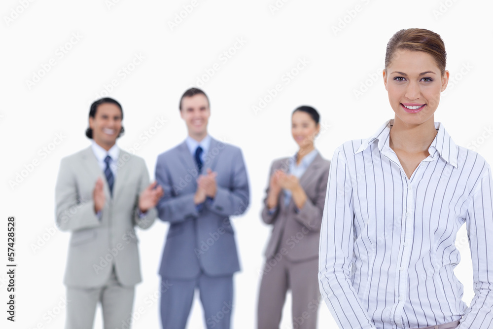 Close-up of a woman smiling with business people applauding Close-up of a woman smiling with business people applauding
