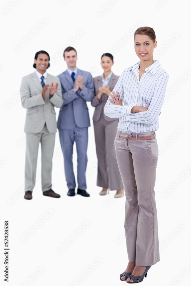 Woman crossing her arms with business people applauding while wa Woman crossing her arms with business people applauding while wa