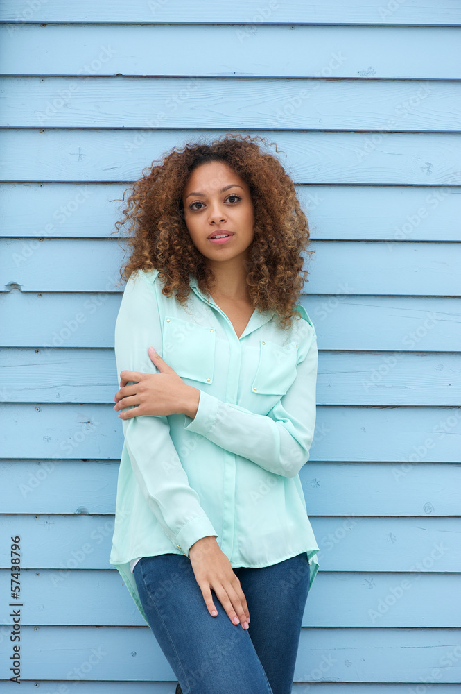 Young woman standing outdoors against blue background