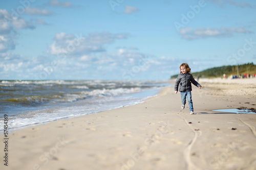 Adorable little girl playing on the beach