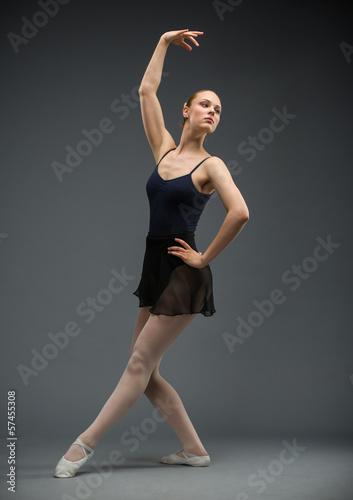 Full length of dancing ballerina, isolated on grey