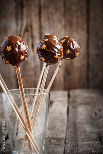 Chocolate Balls with golden Stars on the sticks in glass