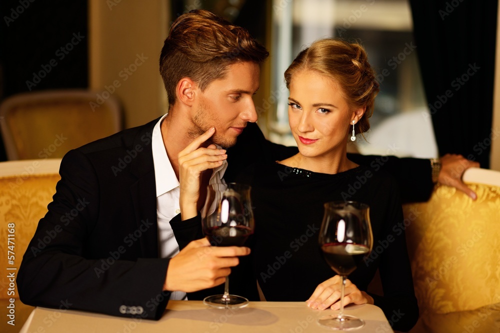 Beautiful young couple with glasses of wine in luxury interior Beautiful young couple with glasses of wine in luxury interior