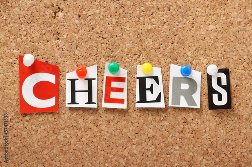 The word Cheers on a cork notice board