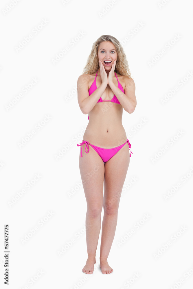 Surprised blonde woman wearing swimsuit while putting her hands
