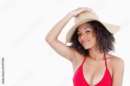 Beautiful woman wearing a swimsuit while holding her hat