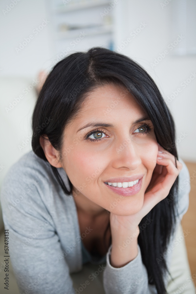 Woman smiling as she holds her head with her palm Woman smiling as she holds her head with her palm
