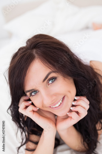 Joyful woman lying on her bed in the morning
