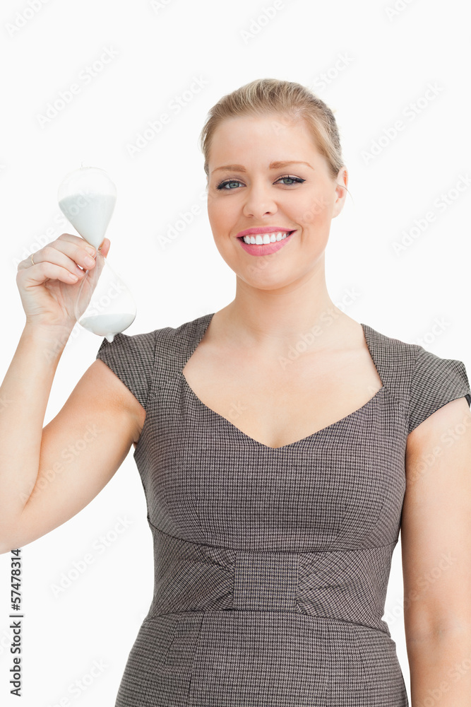 Woman smiling showing a hourglass in her hand Woman smiling showing a hourglass in her hand