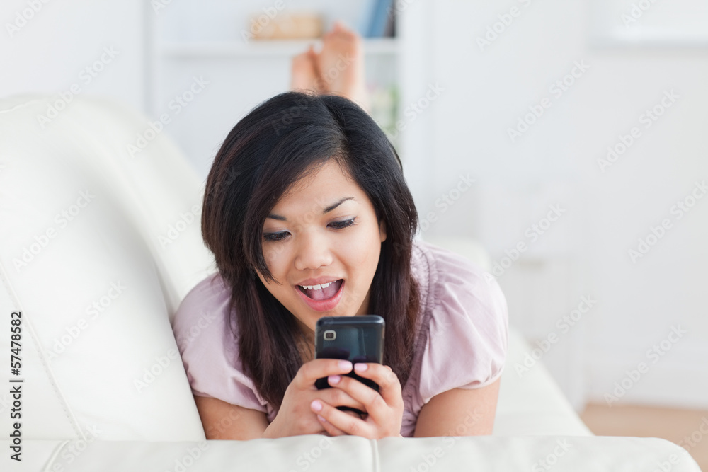 Woman resting on a couch and holding a phone Woman resting on a couch and holding a phone