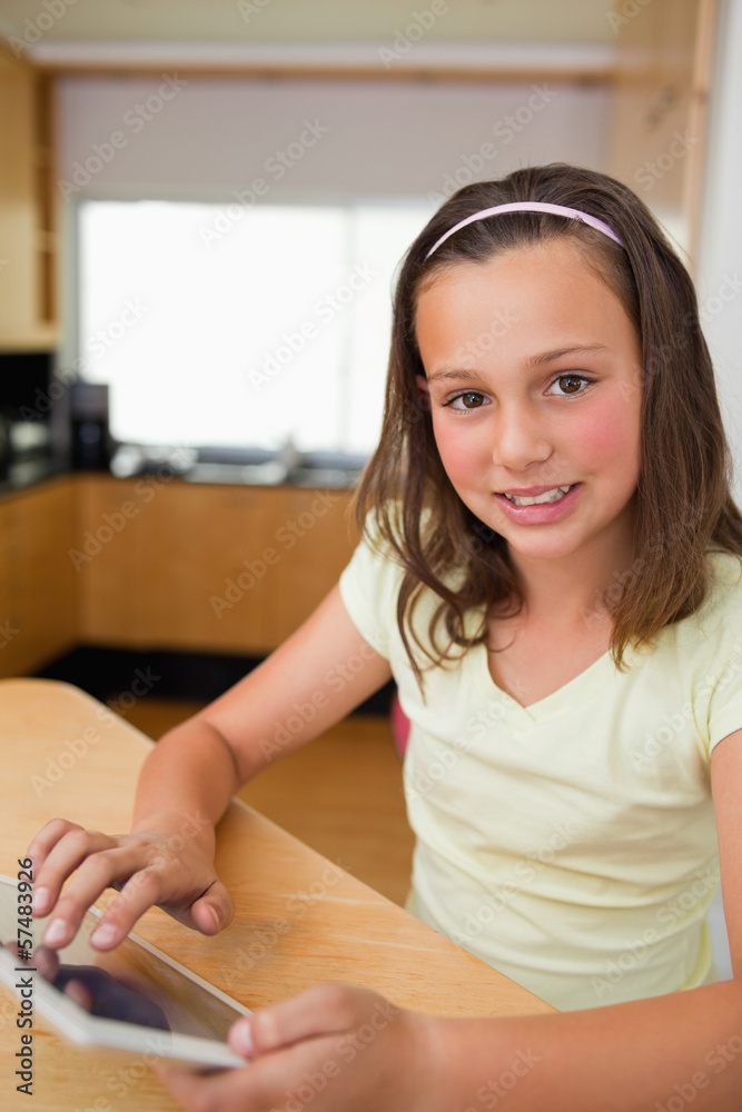 Girl using tablet in the kitchen Girl using tablet in the kitchen