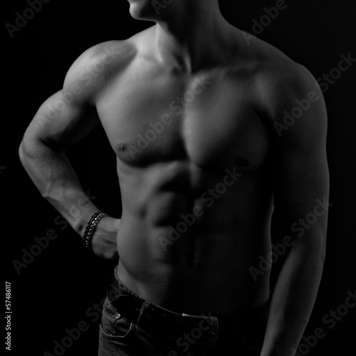 Perfect male body on black background.