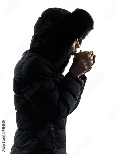 woman winter coat drinking hot drink silhouette